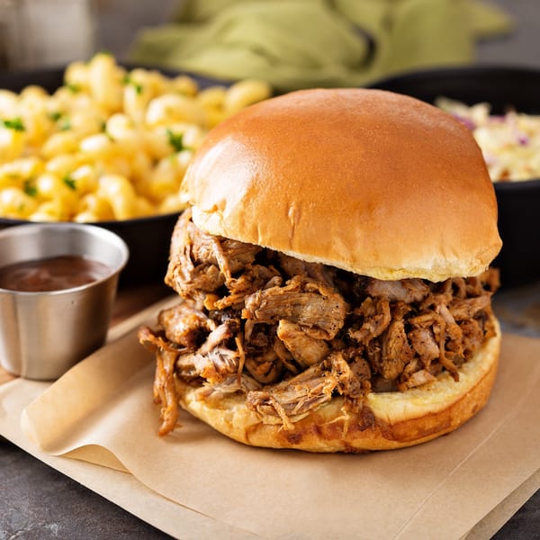 Hard Times BBQ pulled pork sandwich with macaroni and cheese, coleslaw, and a side of sauce.