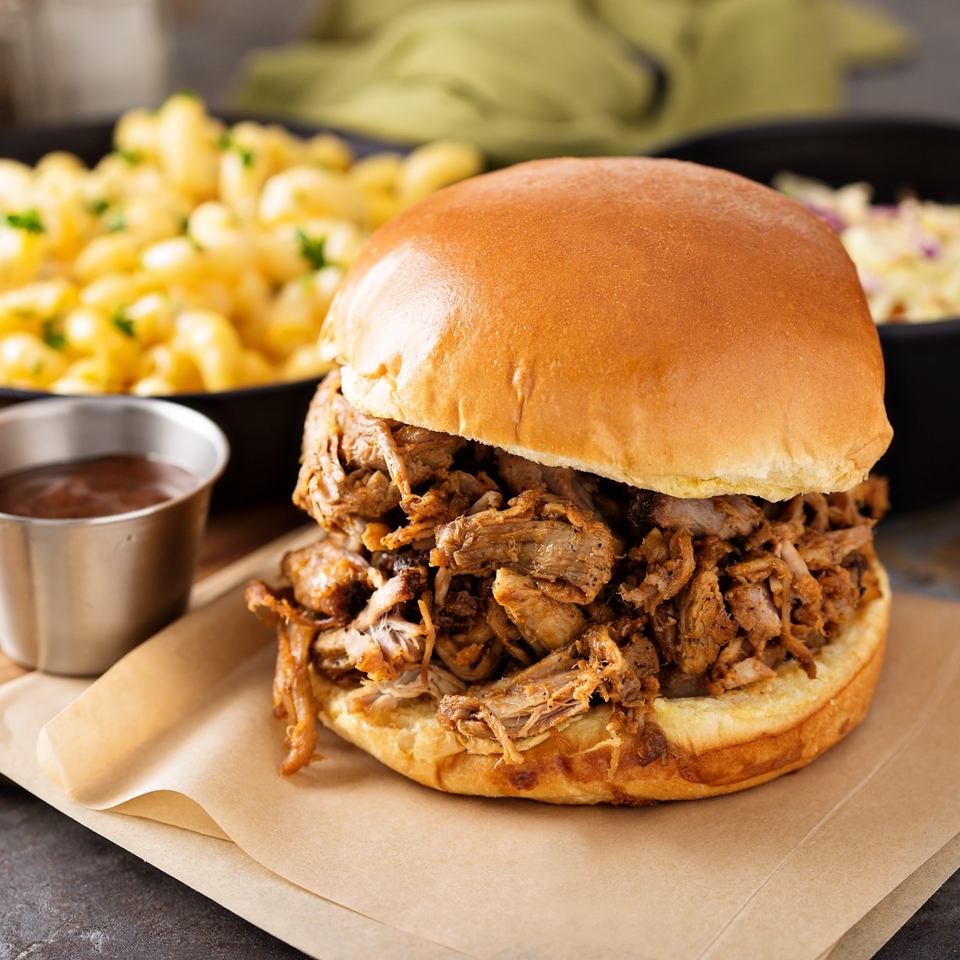 Hard Times BBQ pulled pork sandwich with macaroni and cheese, coleslaw, and a side of sauce.
